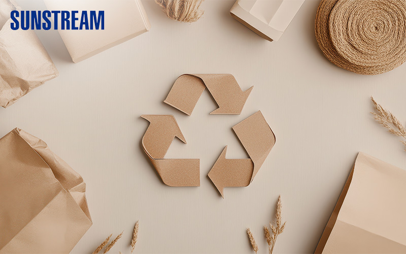 Cardboard cutout of a recycling symbol surrounded by paper products